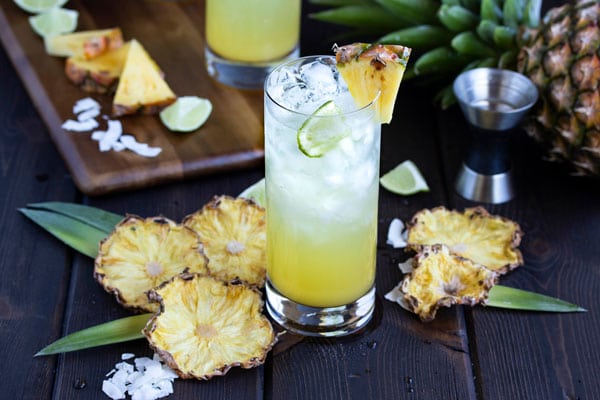 a pineapple and coconut rum drink with dried pineapple slices all around