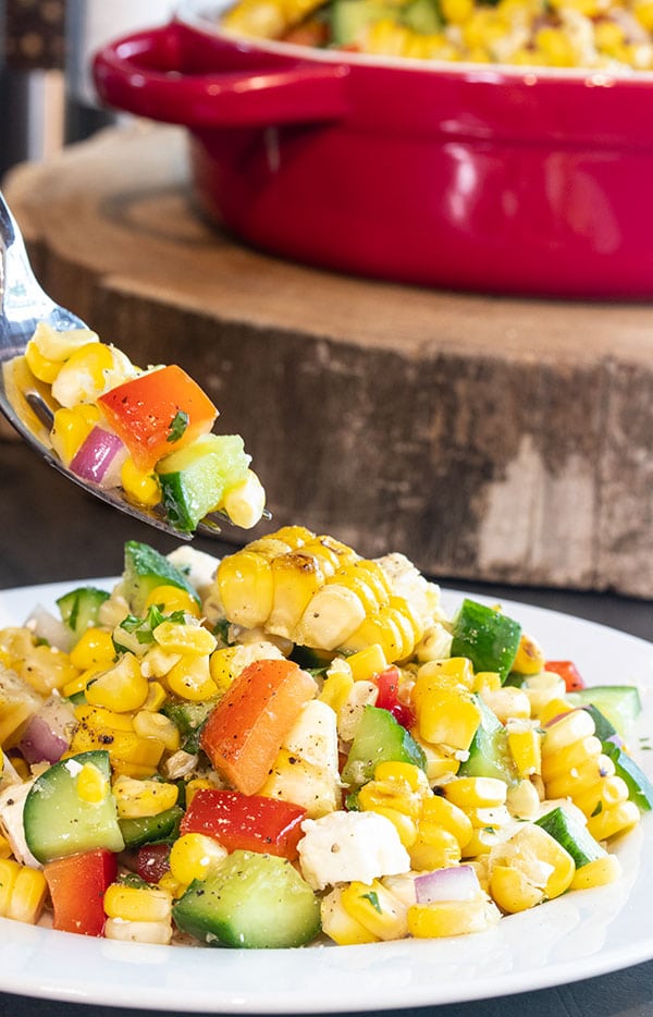 a fork picking up a bite of the corn salad