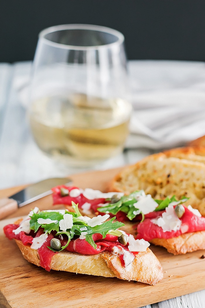 a crostini with beef carpaccio on top