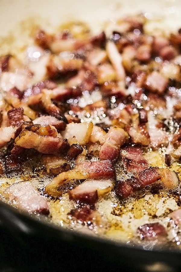 bacon being cooked in a skillet