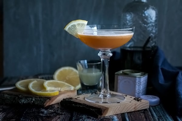 gin sour cocktail with a lime wedge ready to drink