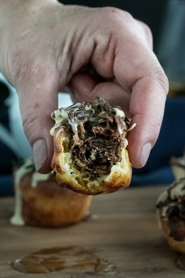 a hand picking up the mini yorkshire pudding