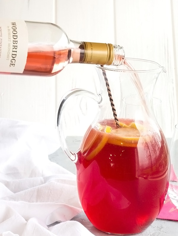 pouring the rose wine into the lemonade sangria pitcher