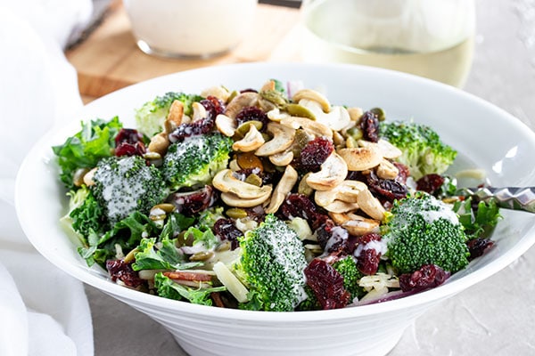 bowl of broccoli salad with cashews and cranberries on top