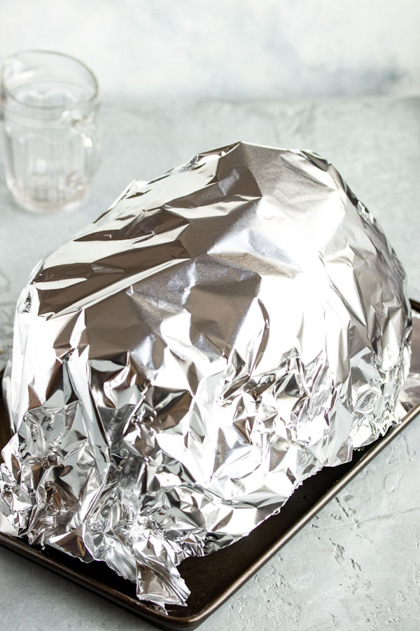 a brined turkey covered in foil to rest