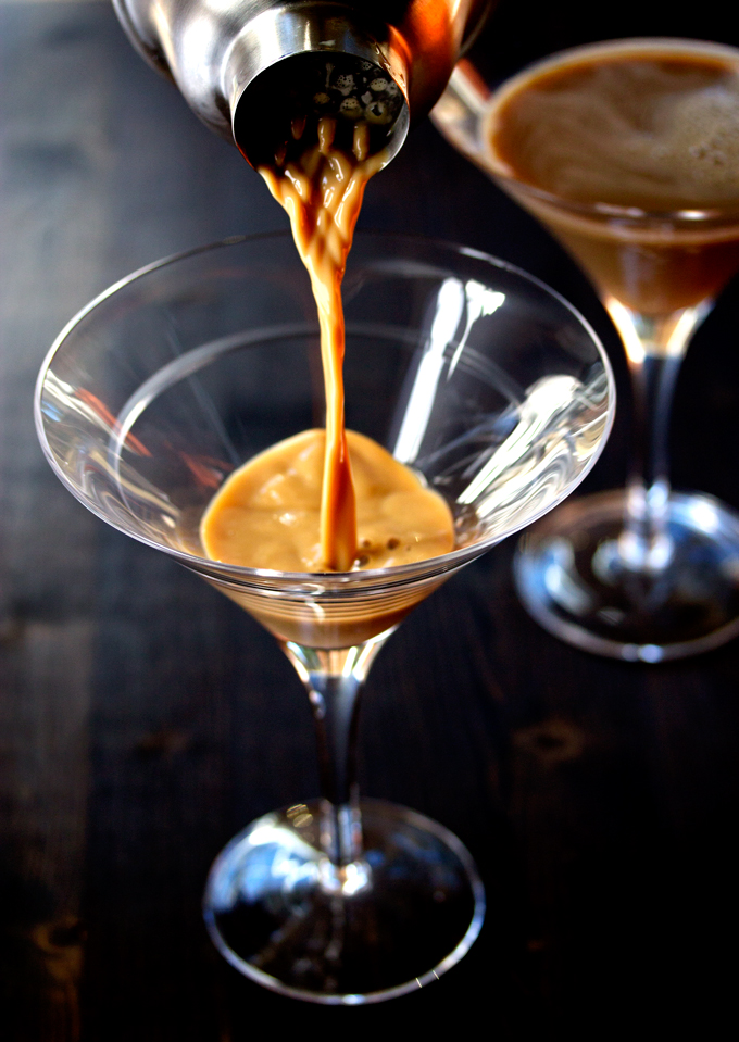 pouring the mixed espresso, vodka and baileys into a martini glass