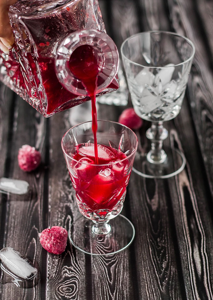 pouring raspberry liqueur into a glass
